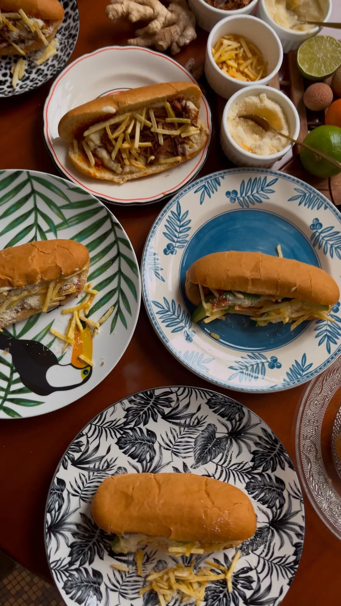 Plusieurs cachorros servis sur des assiettes colorées, avec parmesan, batata palha et citrons verts